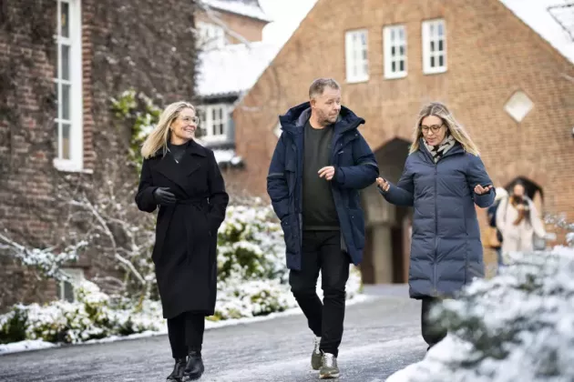 Tre personer gåendes utomhus. foto. 