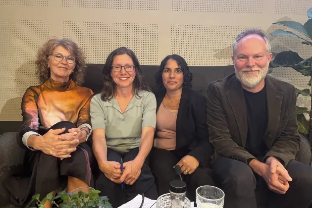 Fyra personer sitter i soffa. 