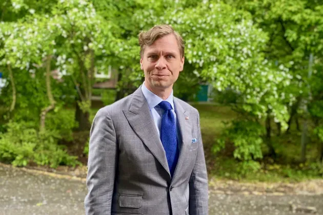 Man mot grön bakgrund utomhus. Foto