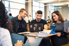 Studenter sitter med dator. Foto